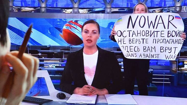 Marina Ovsyannikova segurando um cartaz que diz "Não à Guerra" ao vivo na TV russa, em 15 de março