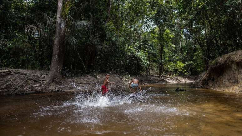 Crianças aproveitam os baixos níveis dos rios para brincar, mas a seca vem causando enormes problemas