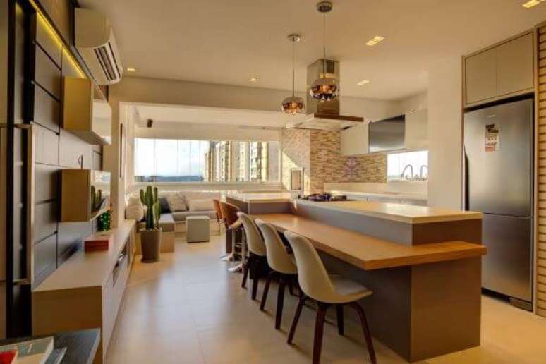28. Decora&ccedil;&atilde;o conceito aberto com altura de bancada de cozinha em quartzo branco e mesa de madeira &ndash; Foto Andrea Petini