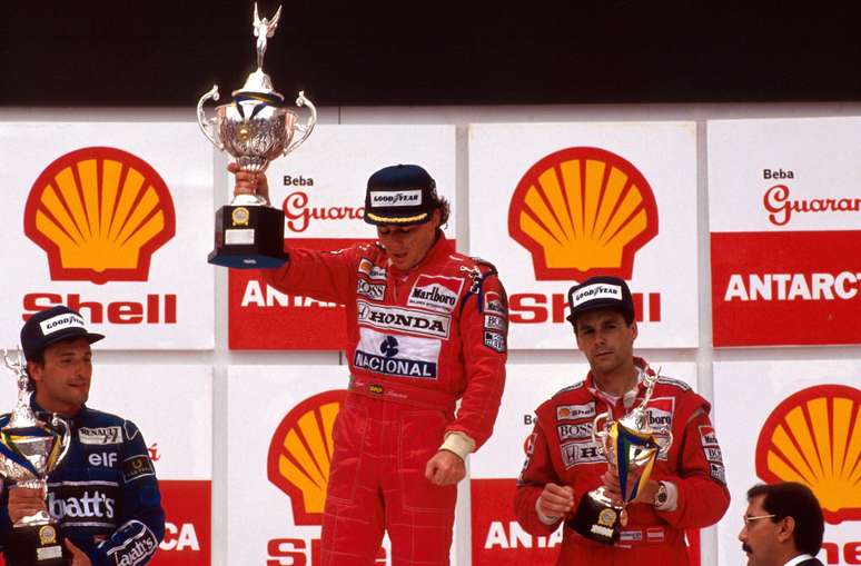 Senna erguendo o trof&eacute;u com dificuldades ap&oacute;s a exaust&atilde;o f&iacute;sica causada pelo GP