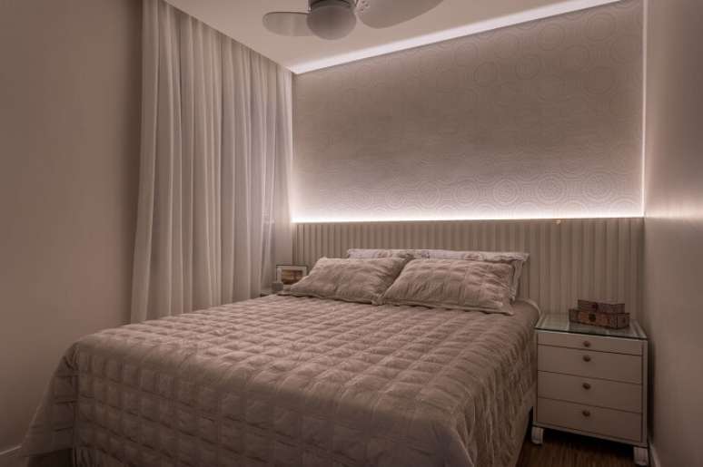 31. Cortina com tecido branco e cabeceira com LED decoram o quarto. Fonte: Marcia Addor