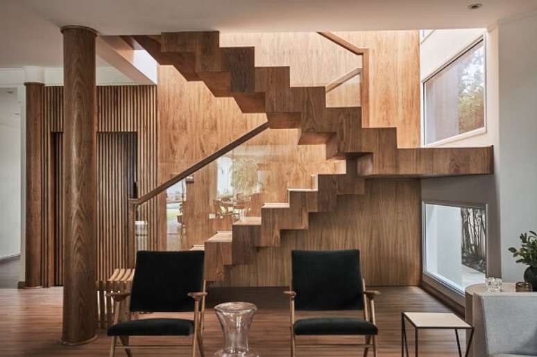 5. Escadas para casa de madeira com poltronas pretas – Foto Piloni Arquitetura