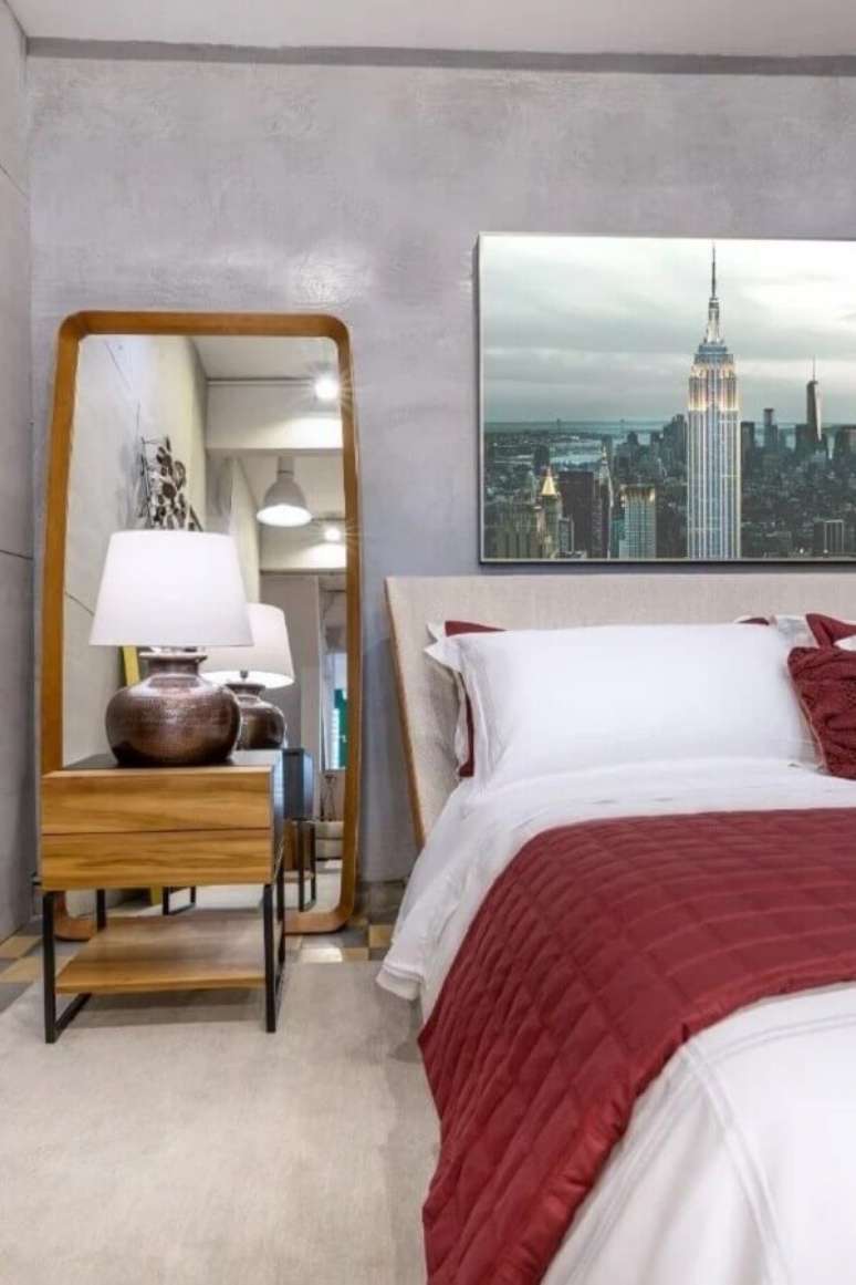 33. Espelho no ch&atilde;o no quarto de casal decorado com parede de cimento queimado &ndash; Foto: Loiel Moveis