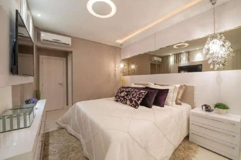 57. Parede de espelho no quarto de casal decorado com lumin&aacute;ria de cristal &ndash; Foto: Actual Design