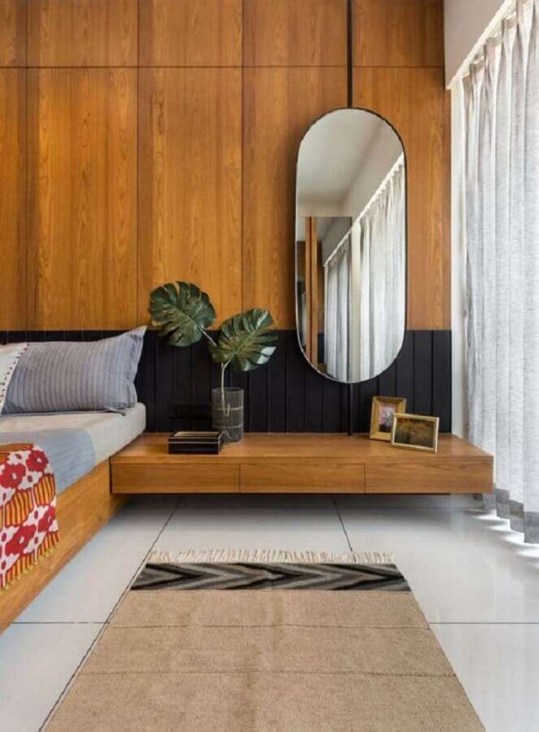 40. Espelho no quarto de casal decorado com parede de madeira &ndash; Foto: Architectural Digest