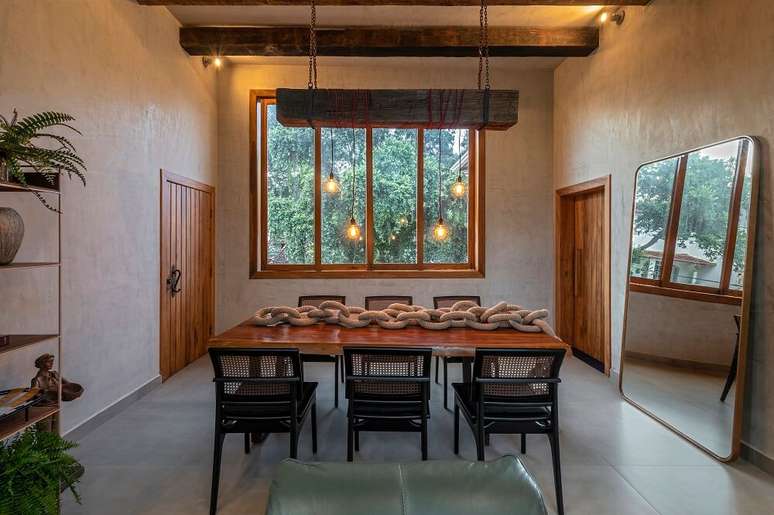 5. Espelho grande de ch&atilde;o e pendente industrial decoram a sala de jantar. Foto: Daniel Mansur Fotografia