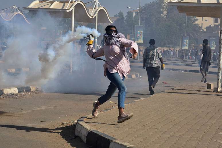 Um manifestante arremessa uma lata de gás lacrimogêneo durante um protesto exigindo o fim do regime militar, em Cartum, Sudão, em 30 de dezembro de 2021