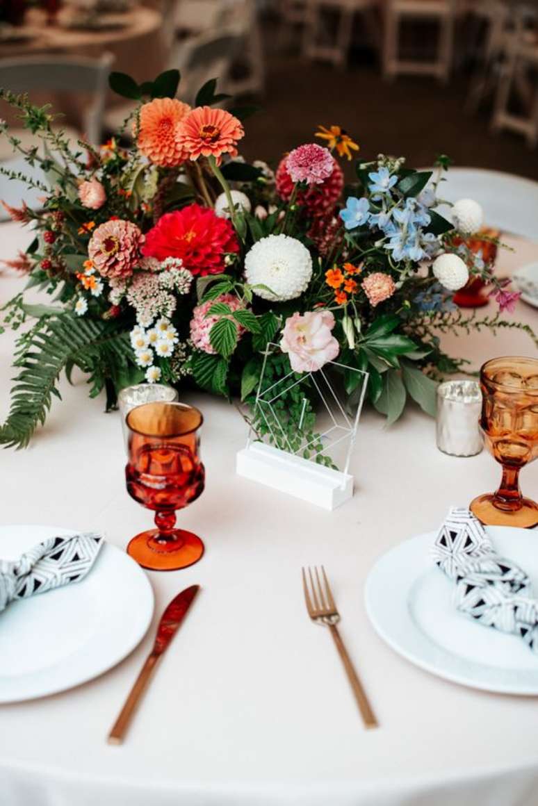 23. Arranjo de mesa de jantar com flores laranja e rosa – Foto junebug Weddings