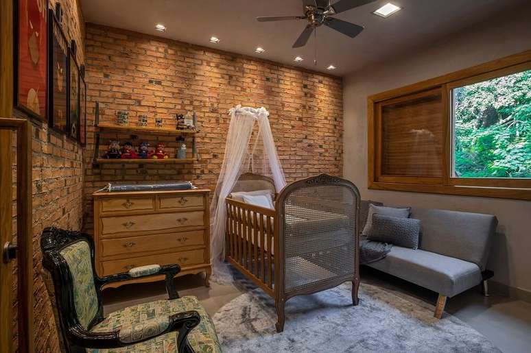 12. Tijolinho aparente e moveis de madeira decoram o quarto de bebe. Foto: Daniel Mansur Fotografia