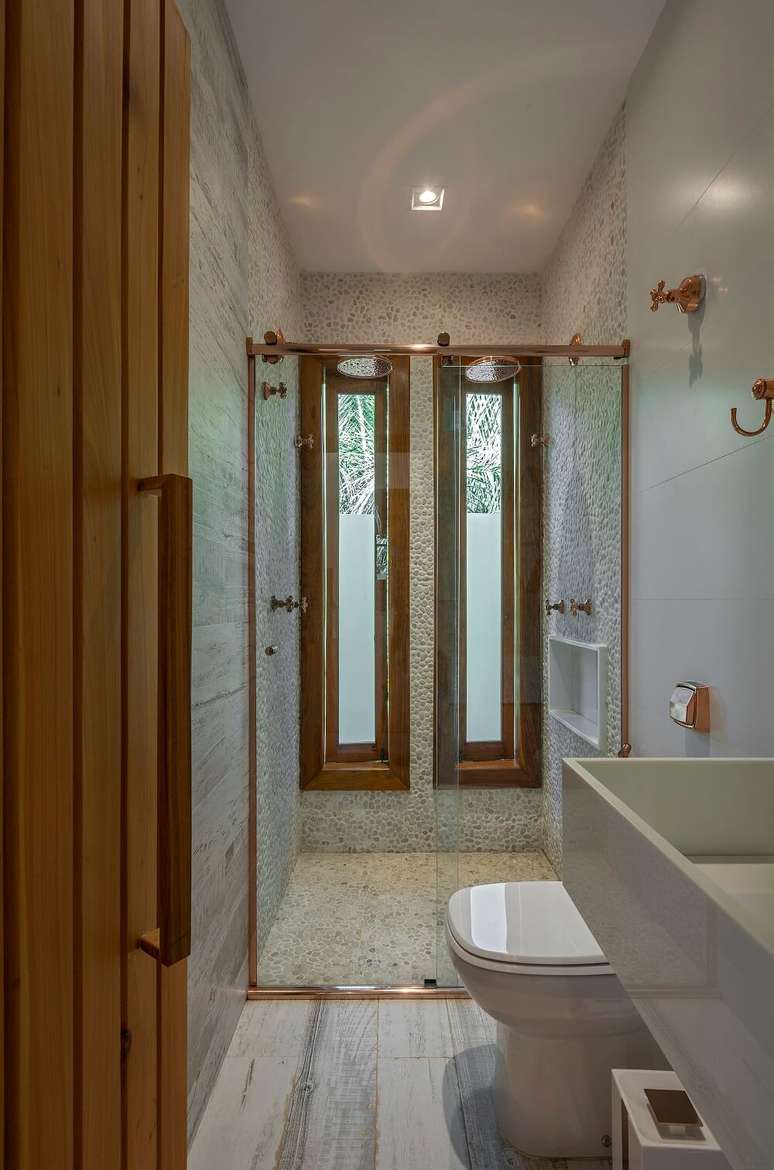 15. Banheiro com dois chuveiros cromados. Foto: Daniel Mansur Fotografia