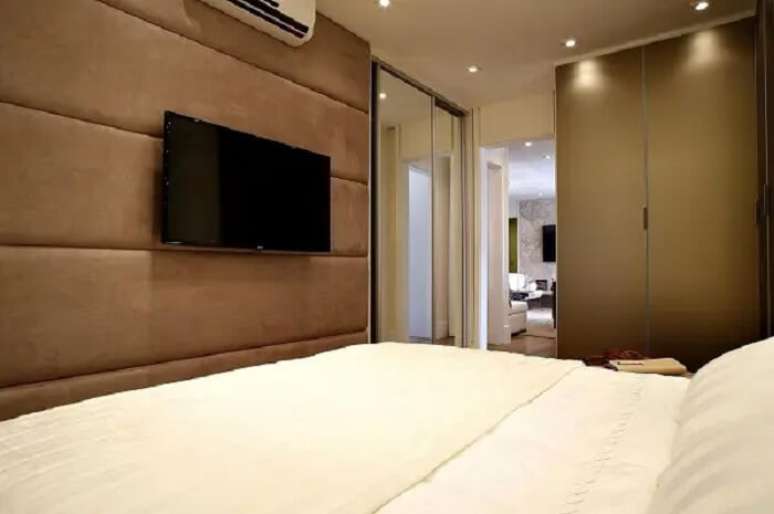 33. Guarda-roupa moderno planejado e tv no quarto. Fonte: BY Arq e Design