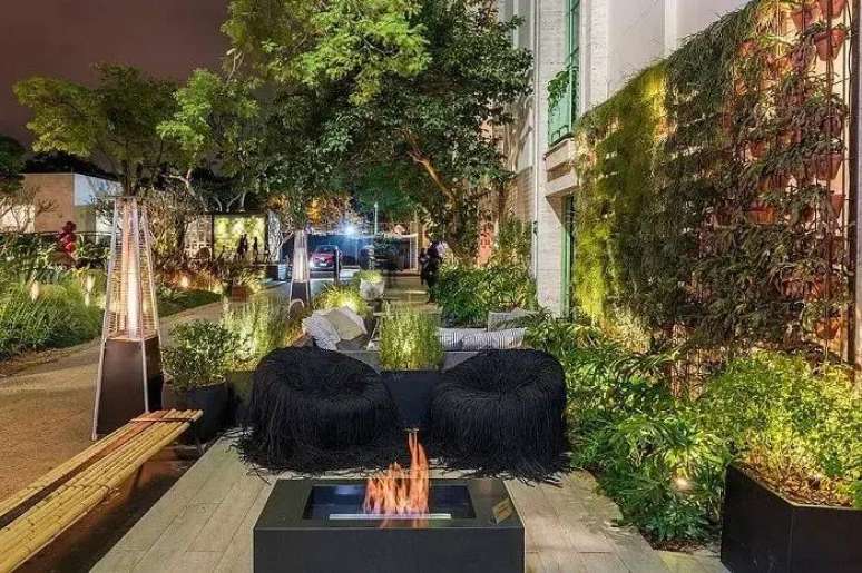 22. Cadeira com assento preto, banco de bambu natural e jardim vertical externo. Fonte: Studio Clari&ccedil;a Lima