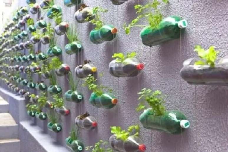 39. Muro chapiscado decorado com jardim vertical externo feito com garrafas PET e plantas. Fonte: Street Art Utopia