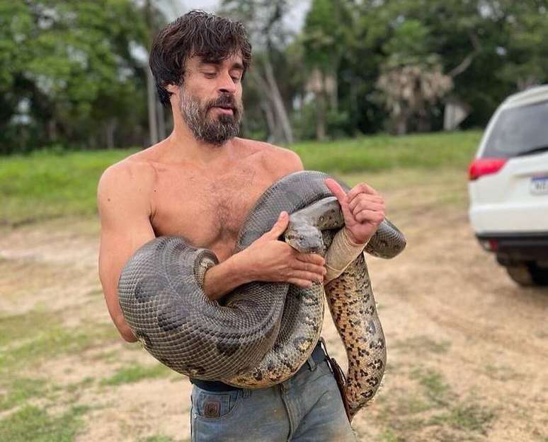 Erom Cordeiro contracenando com sucuri em gravação do remake de 'Pantanal'.