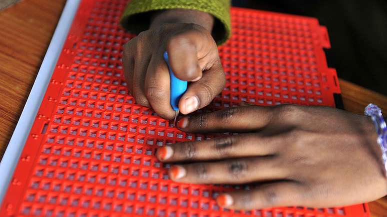 O sistema braille se espalhou pelo mundo — na foto, uma menina indiana escreve em braille