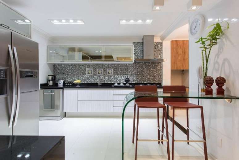 46. Arm&aacute;rio de cozinha grande com bancada de vidro para refei&ccedil;&otilde;es &ndash; Foto Marcia Acaro