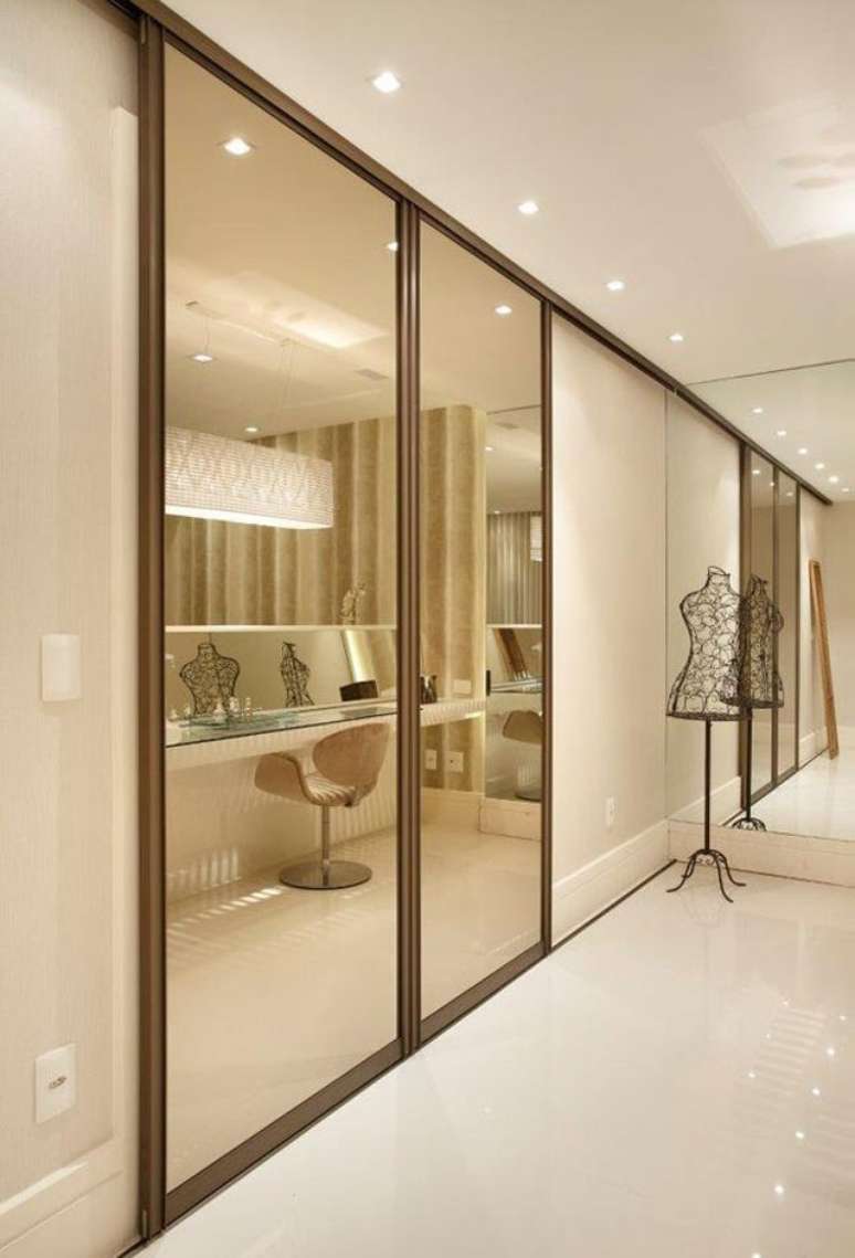 16. Guarda roupa com porta de vidro espelhado no closet moderno – Foto Nardolap