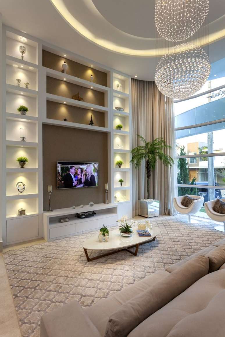 30. Sala de estar luxuosa com vasos pequenos na decora&ccedil;&atilde;o da estante e no centro de mesa &ndash; Foto Aquiles Nicoas Kilaris