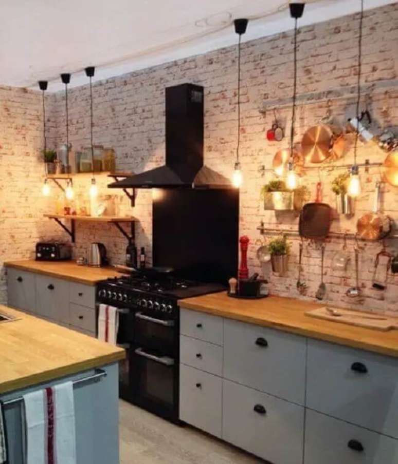 19. Cozinha estilo industrial com luzes e revestimento de tijolo de demolição. Fonte: Apartment Therapy