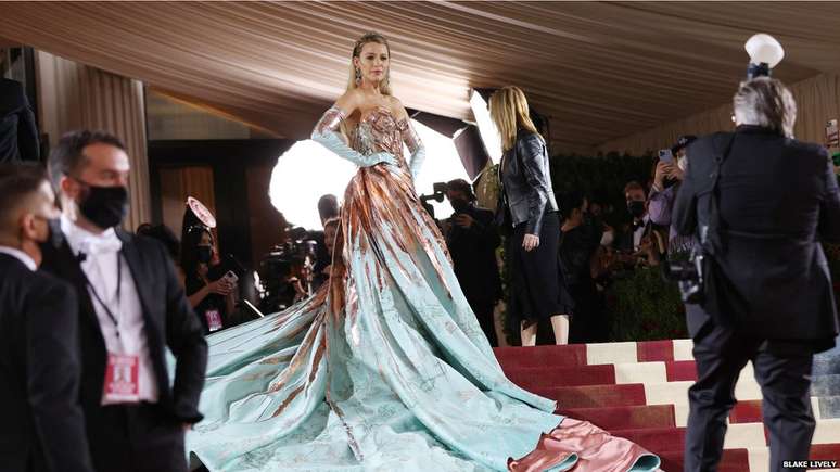 Atriz Blake Lively posa no tapete vermelho após surpreender a multidão ao desdobrar seu vestido para revelar outro vestido mais longo