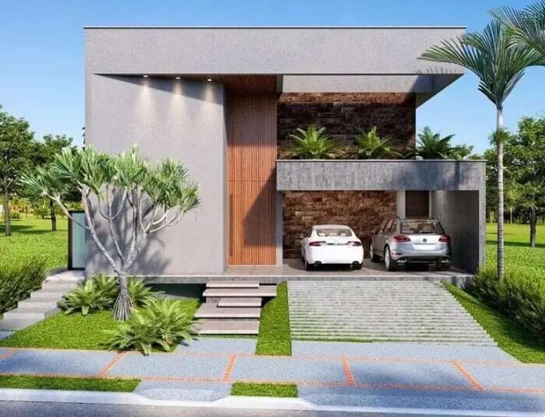 18. Casa com fachada cinza e garagem lateral com rampa para dois carros. Fonte: Deborah Greco Arquitetura