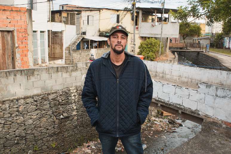 Hélio ao lado do córrego que margeia a favela onde mora 