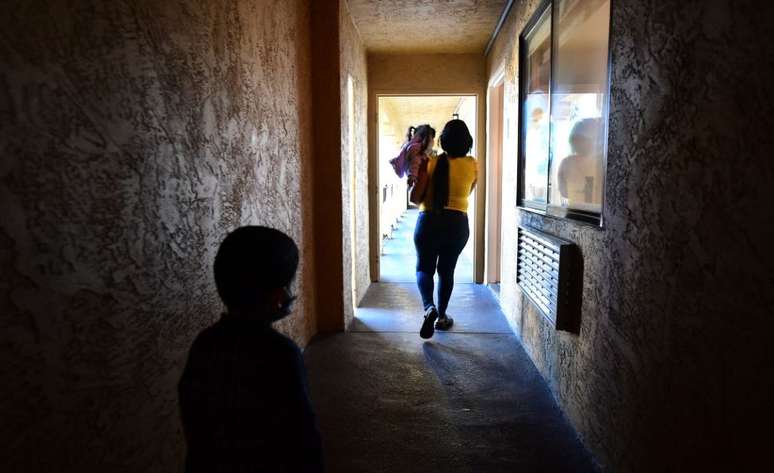 Uma imigrante venezuelana com seus dois filhos em um abrigo de caridade católico em San Diego, Califórnia. Foto tirada em 9 de novembro de 2021, após a reabertura da fronteira, que havia sido fechada devido à pandemia