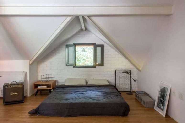 24. Cama embaixo da janela: a cama foi posicionada junto a parede de tijolinhos aparentes. Fonte: Baumann Arquitetura