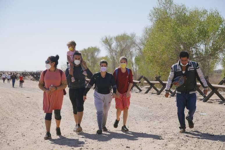 Migrantes de vários países, incluindo Colômbia, Cuba e Venezuela que chegam aos EUA, após cruzarem o rio Colorado, vindos do México. Esta foto foi tirada em Yuma, Arizona, em 21 de fevereiro