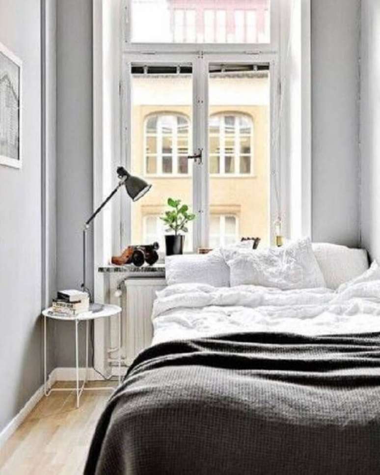 43. Quarto clean e minimalista com cama embaixo da janela. Fonte: Infinity Design