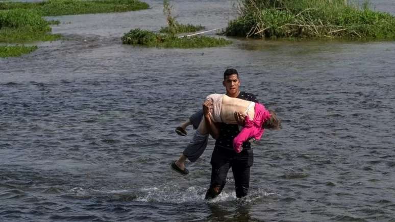 Em maio de 2021, esta foto circulou amplamente na internet. Uma idosa venezuelana cruzou o Rio Grande do México aos Estados Unidos nos braços de um jovem