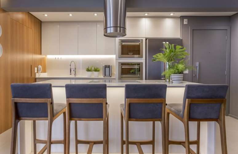 9. Armário de cozinha americana simples na cor branca com banquetas azuis – Foto Altera Arquitetura