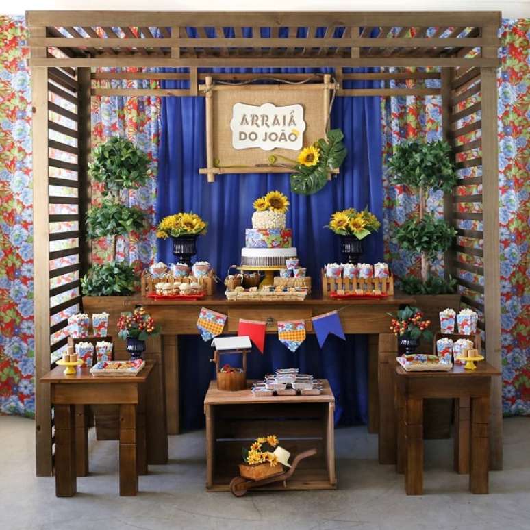 74. Decoração de festa junina infantil com mesa de madeira e girassois – Foto DEcore e Comemore
