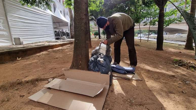 O garçom Rulian Amorim, de 34 anos, vive sozinho nas ruas e se protege do frio usando um pedaço de papelão, um plástico preto e um cobertor