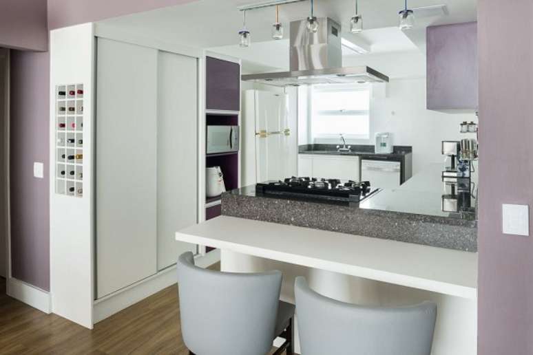 25. Cozinha americana simples com cadeira alta para bancada branca e decora&ccedil;&atilde;o moderna &ndash; Foto KTA Arquitetura