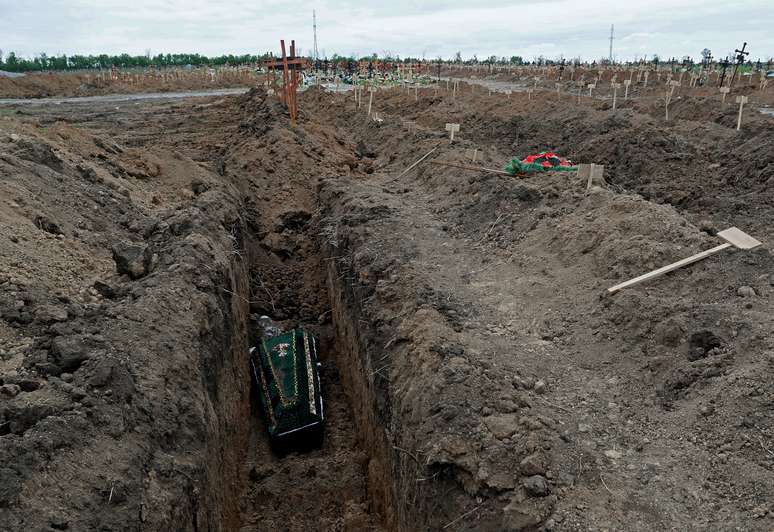 Foto de 22 de maio mostra caix&atilde;o sendo colocado em t&uacute;mulo do cemit&eacute;rio no assentamento de Staryi Krym, nos arredores de Mariupol