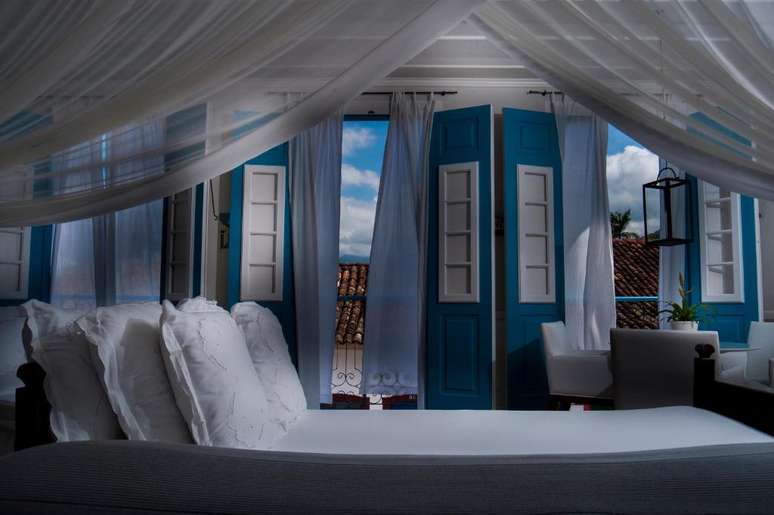 Enquadramentos de uma das su&iacute;tes, com cama king size e banheira de hidromassagem.