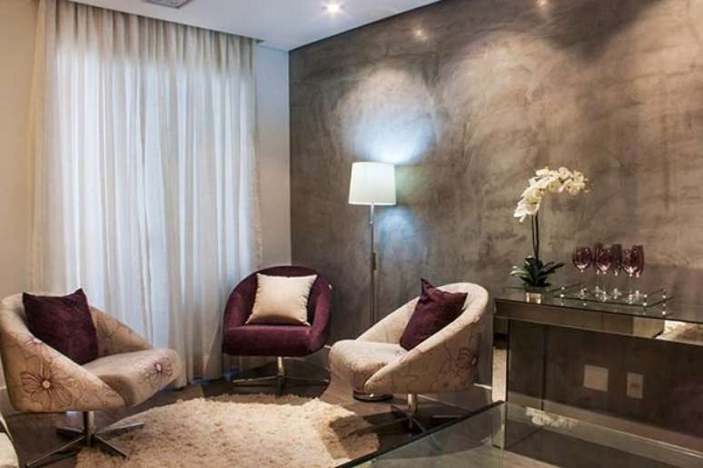 37. Sala de estar com marmorato na parede cinza e poltrona roxa e branca – Foto Decor Facil