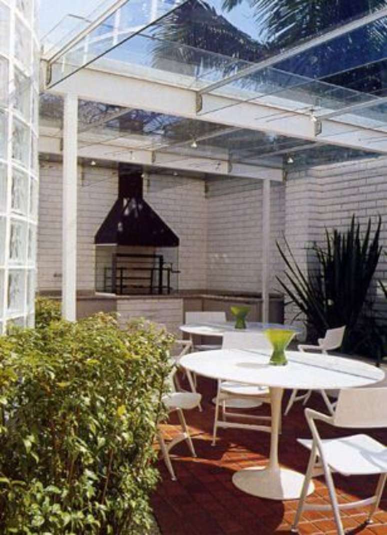 11. Varanda gourmet com telhado de vidro em estrutura met&aacute;lica clara, combinando com o restante da decora&ccedil;&atilde;o. Projeto de Brunete Fraccaroli