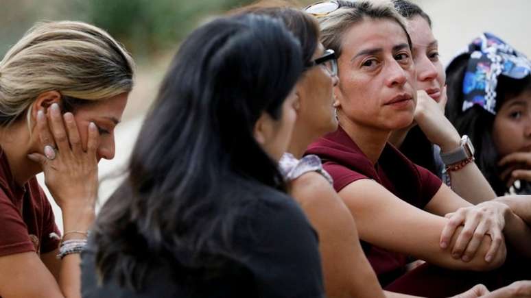 Pessoas choram perto de centro cívico para onde crianças que sobreviveram a ataque foram levadas