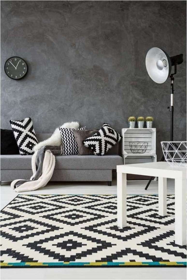 27. Marmorato na parede com sofá cinza e tapete preto e branco – Foto Decor Facil