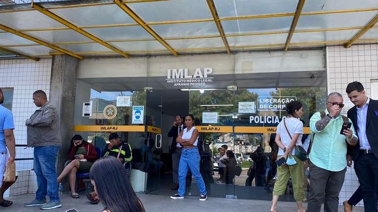 Foto enquadra um grupo de pessoas em frente ao IML do Rio de Janeiro