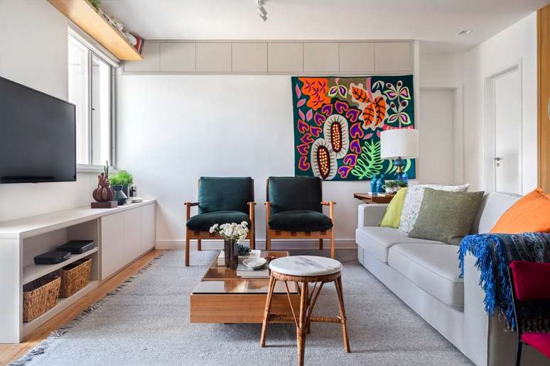 Poltronas verdes da Casa e Forma, mesa de centro e sof&aacute; da Way Design e tapete da Galeria Hathi