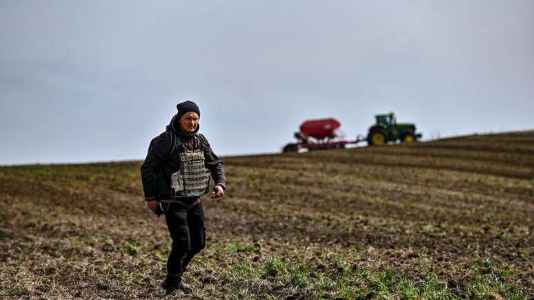 Um agricultor usa um colete &agrave; prova de balas durante a semeadura da primavera na regi&atilde;o de Zaporizhzhia