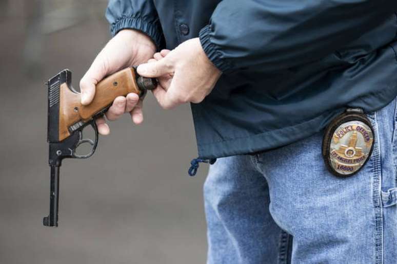 Um policial carregando uma pistola