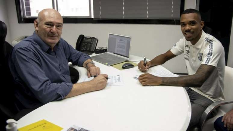 Lucas Pires ao lado do presidente Andres Rueda na renovação de contrato (Foto: Divulgação/Santos)