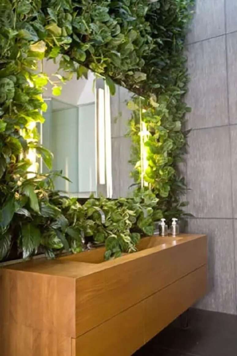 59. A parede de plantas artificiais no banheiro serviu como moldura do espelho. Fonte: Jungle Bathroom