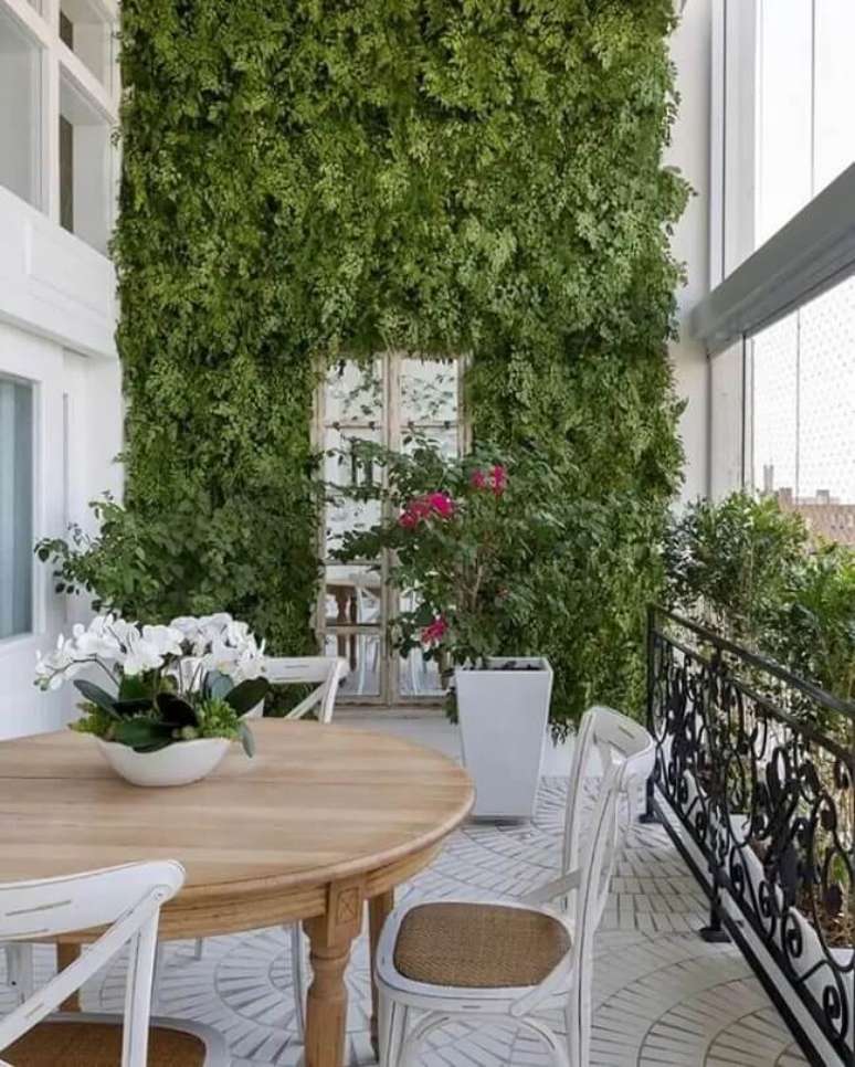 60. Varanda sofisticada com parede de plantas. Fonte: Martins Valente