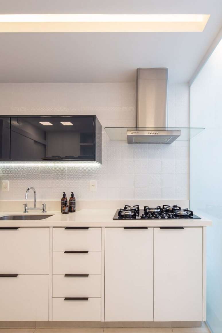 6. Cozinha clean branca com cooktop e coifa de inox – Foto Vita Arquitetura