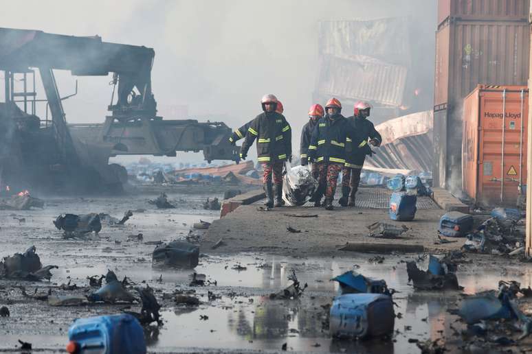 Bombeiros carregam corpo após um grande incêndio em um depósito de contêineres em Sitakunda, perto da cidade portuária de Chittagong, Bangladesh